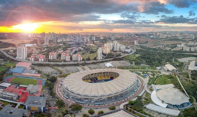 Aerial view of Bukit Jalil Kuala Lumpur showing the National Stadium, Axiata Arena, surrounding condominiums and city skyline at sunset